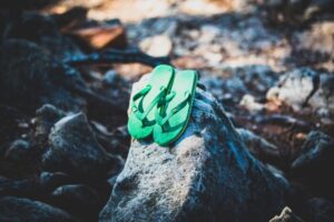 green flip flops on gray rock